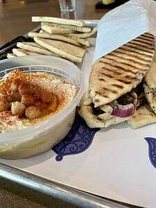 Mediterranean pita with grilled vegetables, hummus, and spices, served fresh at The Migoni Kitchen.