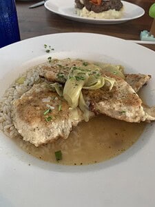 Delicious grilled fish dish with lemon butter sauce, rice, and fresh herbs, perfect for seafood love.