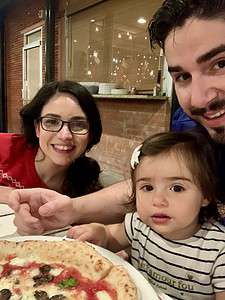 Family enjoying pizza at The Migoni Kitchen restaurant.