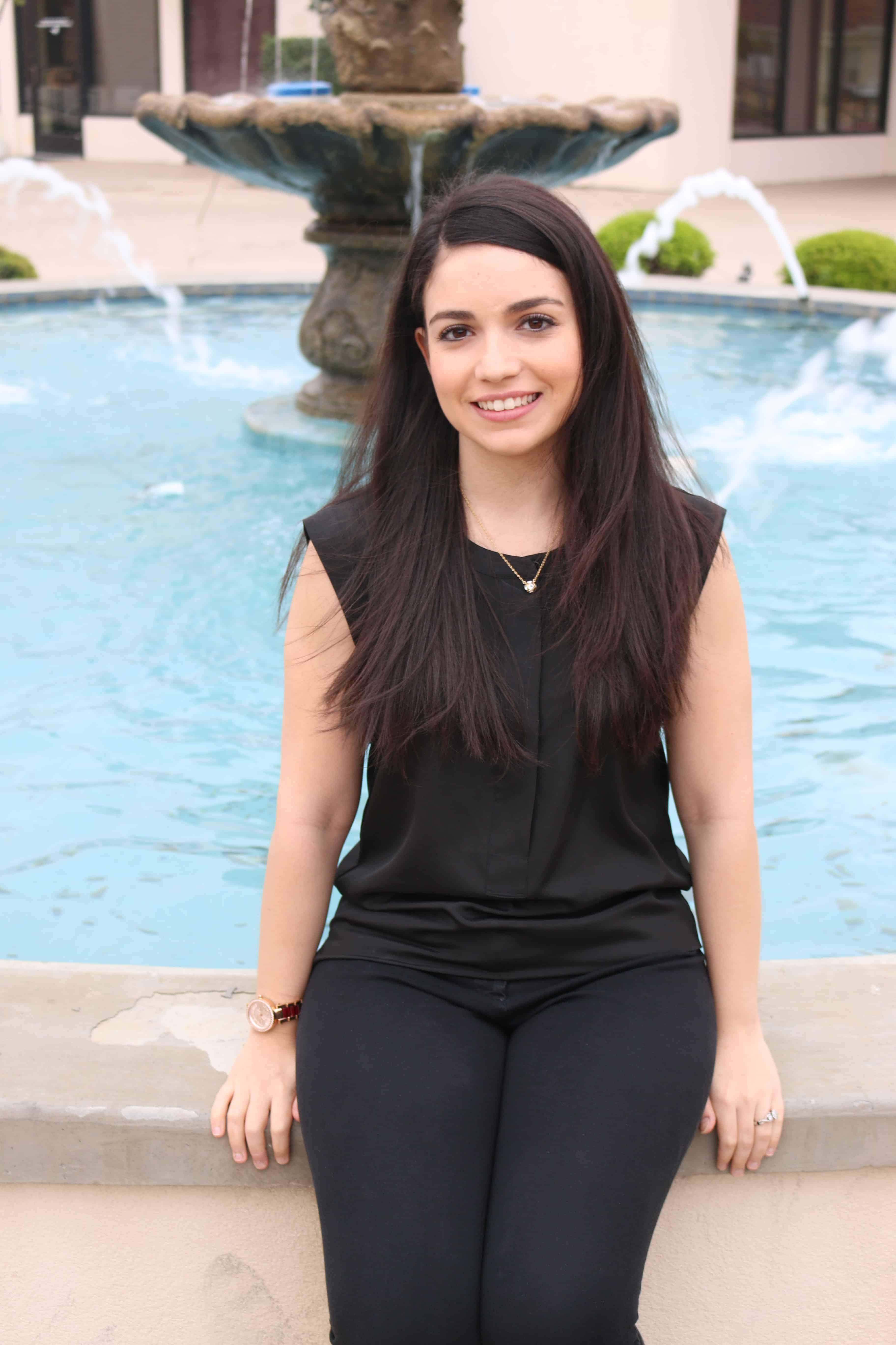 Advocate smiling near fountain, promoting infertility awareness and support.